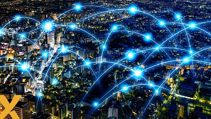 Stad bij nacht met verbonden lichtpunten die digitale netwerkverbindingen en datastromen symboliseren.