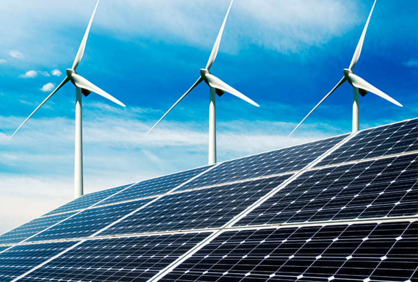 Zonnepanelen op de voorgrond met drie windturbines erachter tegen een blauwe lucht.